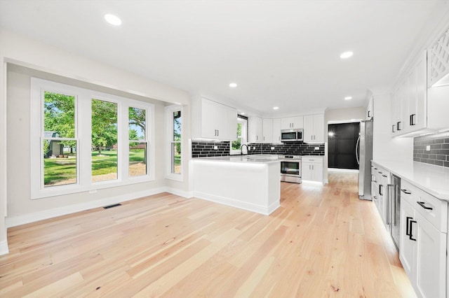 14814 Oakcreek Ct, Orland Park, IL 60467 - kitchen featuring appliances with stainless steel finishes, tasteful backsplash, light countertops, light wood-type flooring, and recessed lighting