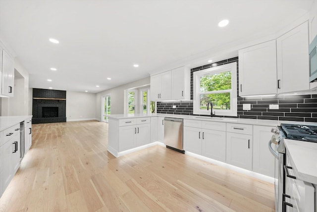 14814 Oakcreek Ct, Orland Park, IL 60467 - kitchen with appliances with stainless steel finishes, open floor plan, light wood-style flooring, a peninsula, and tasteful backsplash
