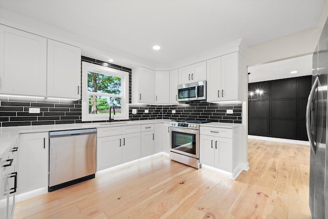 14814 Oakcreek Ct, Orland Park, IL 60467 - kitchen featuring stainless steel appliances, light wood-style flooring, white cabinetry, tasteful backsplash, and light countertops