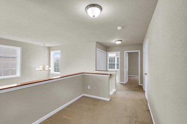 2303 Blanche Ln Unit B, Champaign, IL 61822 - hall featuring a chandelier, light carpet, and an upstairs landing