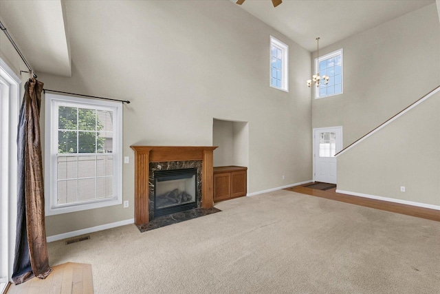 2303 Blanche Ln Unit B, Champaign, IL 61822 - unfurnished living room featuring carpet flooring, a high ceiling, ceiling fan, a premium fireplace, and a chandelier