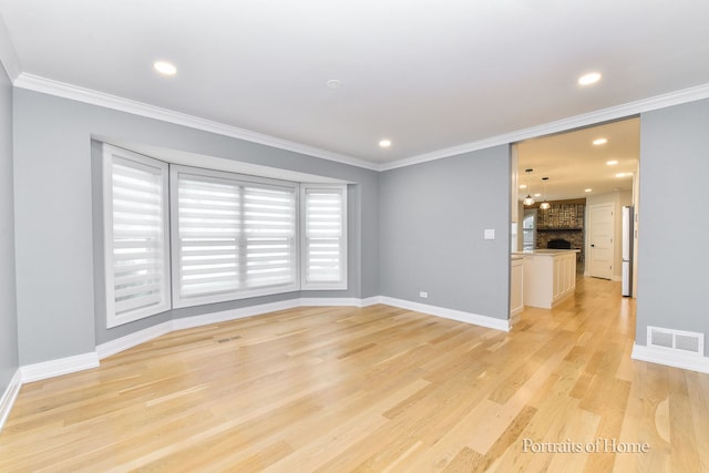 631 S Whispering Hills Dr, Naperville, IL 60540 - spare room featuring light wood-style floors, ornamental molding, recessed lighting, and a large fireplace