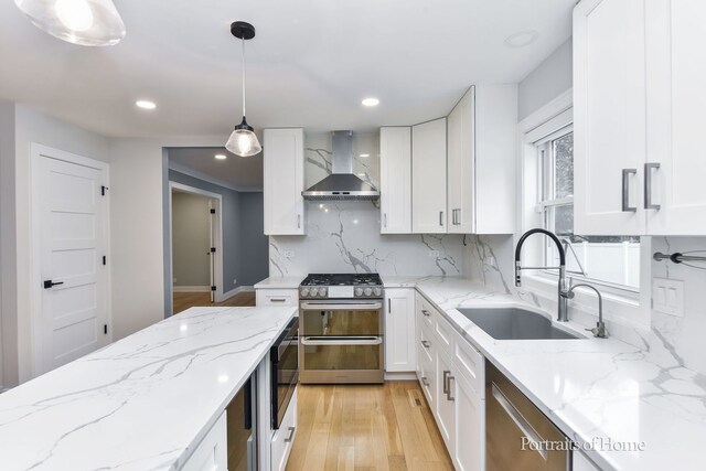 631 S Whispering Hills Dr, Naperville, IL 60540 - kitchen with wall chimney exhaust hood, appliances with stainless steel finishes, light wood-style flooring, white cabinetry, and tasteful backsplash