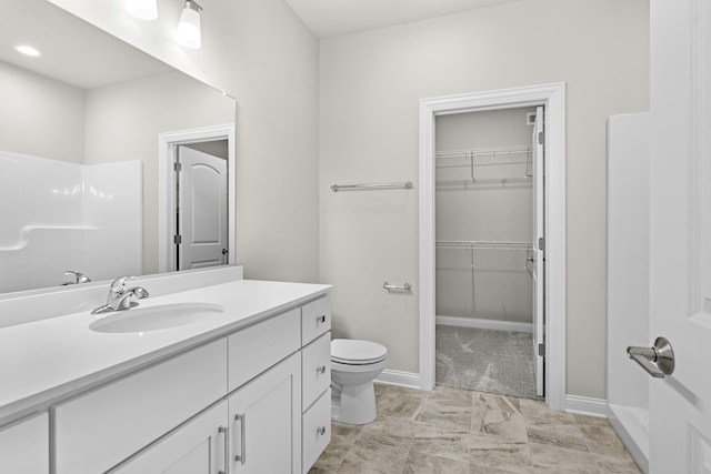 6375 Jasmine Ave, Portage, IN 46368 - bathroom featuring vanity, toilet, a walk in closet, and baseboards