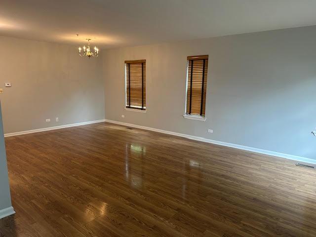 1127 Orleans Dr, Mundelein, IL 60060 - empty room featuring a chandelier, baseboards, and dark wood-style flooring