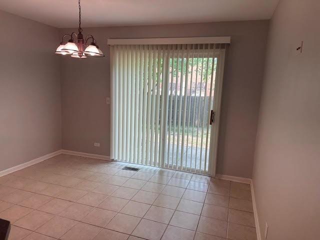 1127 Orleans Dr, Mundelein, IL 60060 - spare room featuring light tile patterned floors, a chandelier, and baseboards