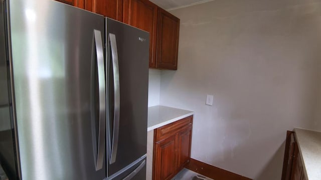 510 W Harrison St, Villa Grove, IL 61956 - kitchen featuring freestanding refrigerator, light countertops, and brown cabinetry