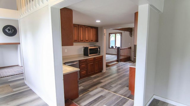 510 W Harrison St, Villa Grove, IL 61956 - kitchen with appliances with stainless steel finishes, wood finished floors, light countertops, brown cabinetry, and recessed lighting