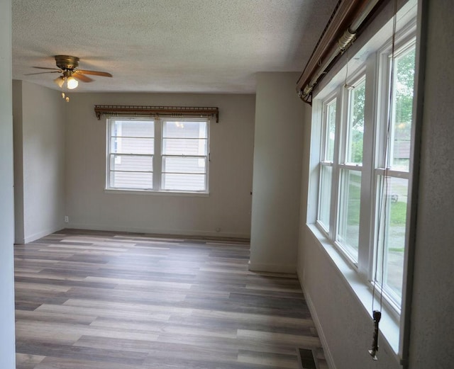 510 W Harrison St, Villa Grove, IL 61956 - empty room with a textured ceiling, plenty of natural light, wood finished floors, and ceiling fan