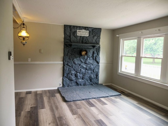 510 W Harrison St, Villa Grove, IL 61956 - unfurnished dining area with wood finished floors, baseboards, and a textured ceiling