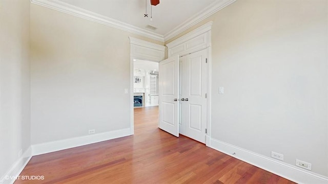 2540 W Diversey Ave Unit 404, Chicago, IL 60647 - empty room with crown molding, wood finished floors, baseboards, a fireplace, and a ceiling fan