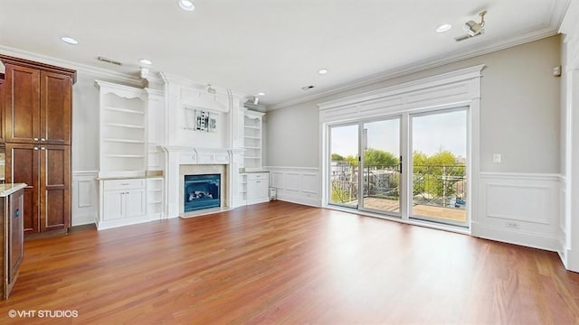 2540 W Diversey Ave Unit 404, Chicago, IL 60647 - unfurnished living room with ornamental molding, a decorative wall, wood finished floors, a fireplace, and wainscoting