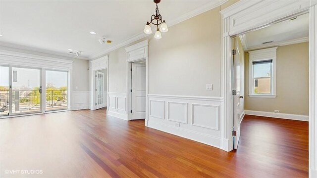 2540 W Diversey Ave Unit 404, Chicago, IL 60647 - unfurnished room featuring crown molding, plenty of natural light, wood finished floors, and wainscoting
