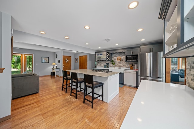 28 Lions Rd, Sandwich, IL 60548 - kitchen featuring appliances with stainless steel finishes, a breakfast bar, tasteful backsplash, a center island, and light wood-type flooring