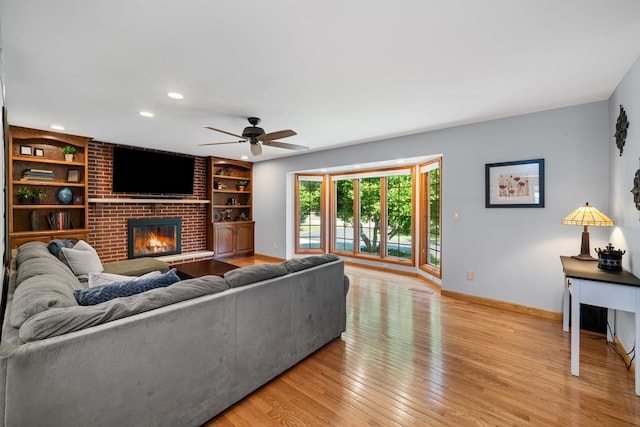 28 Lions Rd, Sandwich, IL 60548 - living room with light wood-type flooring, a ceiling fan, a fireplace, built in features, and recessed lighting