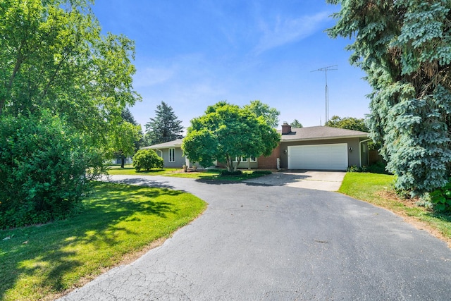 28 Lions Rd, Sandwich, IL 60548 - obstructed view of property featuring asphalt driveway, a garage, a chimney, and a front yard