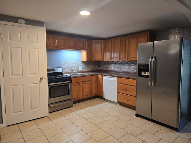 1003 S Pleasantview Dr, Tuscola, IL 61953 - kitchen with stainless steel appliances, dark countertops, a sink, light tile patterned floors, and backsplash