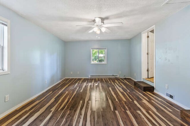 1003 S Pleasantview Dr, Tuscola, IL 61953 - spare room with hardwood / wood-style flooring, ceiling fan, a baseboard heating unit, baseboards, and a textured ceiling