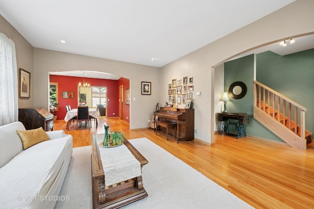 9008 Marmora Ave, Morton Grove, IL 60053 - living area featuring arched walkways, wood finished floors, stairs, a chandelier, and recessed lighting