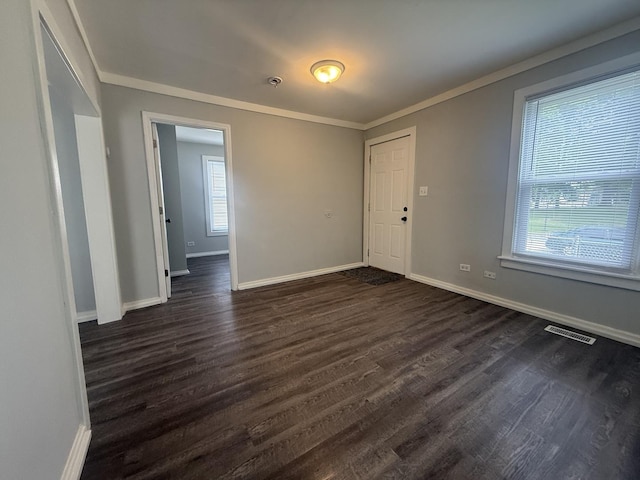 557 W Water St, Waukegan, IL 60085 - empty room with healthy amount of natural light, dark wood finished floors, and ornamental molding