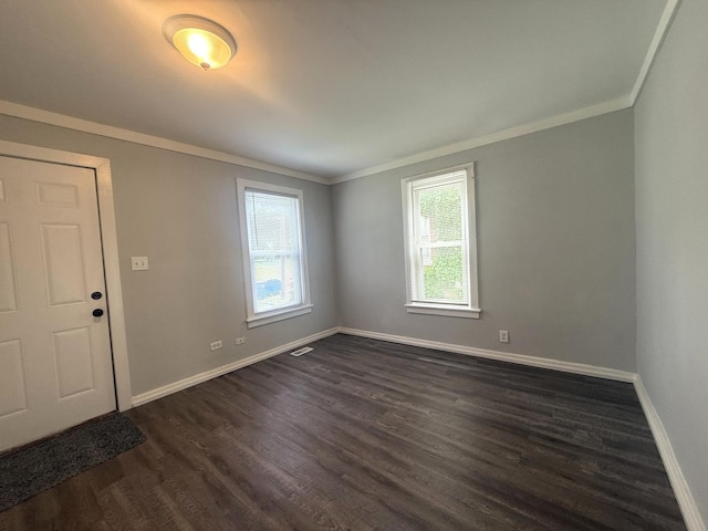 557 W Water St, Waukegan, IL 60085 - spare room featuring dark wood-type flooring and crown molding