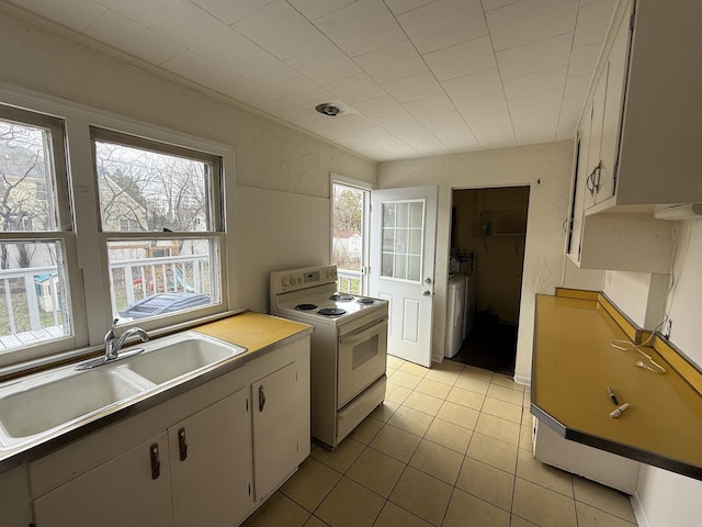 1310 S Sumner St, Wheaton, IL 60187 - kitchen featuring white range with electric stovetop, a sink, light tile patterned floors, light countertops, and white cabinets