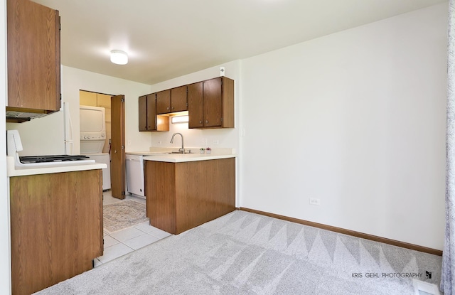 620 Mallard Ct Unit C1, Bartlett, IL 60103 - kitchen with estacked washer and dryer, white appliances, light countertops, a sink, and a peninsula