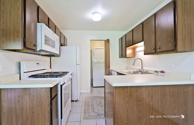 620 Mallard Ct Unit C1, Bartlett, IL 60103 - kitchen featuring white appliances, stacked washer / drying machine, a sink, light tile patterned floors, and a peninsula
