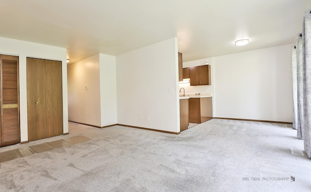 620 Mallard Ct Unit C1, Bartlett, IL 60103 - unfurnished living room with light carpet, a sink, and baseboards