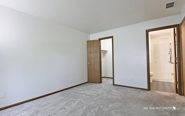 620 Mallard Ct Unit C1, Bartlett, IL 60103 - unfurnished bedroom with light colored carpet, baseboards, a walk in closet, connected bathroom, and a closet
