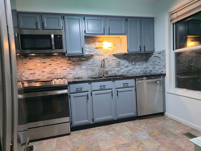 1246 Robin Dr, Carol Stream, IL 60188 - kitchen featuring stainless steel appliances, a sink, decorative backsplash, stone finish flooring, and dark stone counters