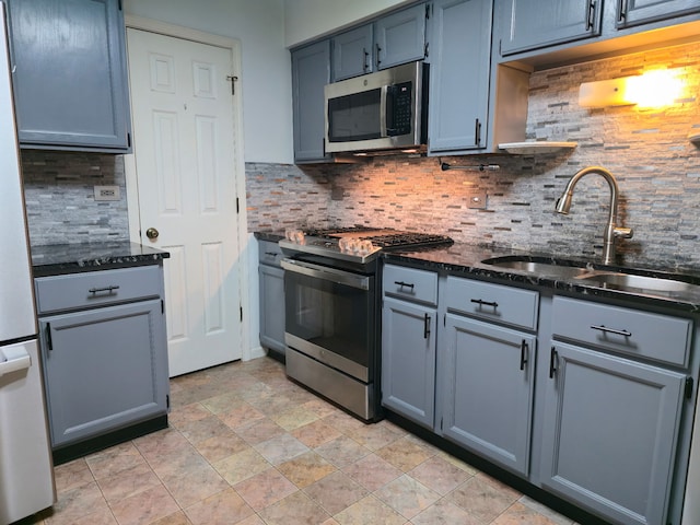 1246 Robin Dr, Carol Stream, IL 60188 - kitchen featuring appliances with stainless steel finishes, a sink, decorative backsplash, stone finish floors, and dark stone counters