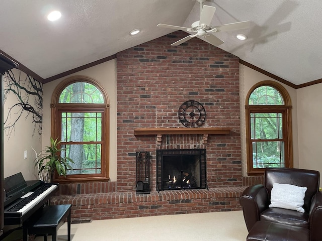 26136 E 2200 N Rd, Lexington, IL 61753 - carpeted living area with vaulted ceiling, a fireplace, ornamental molding, a ceiling fan, and a textured ceiling