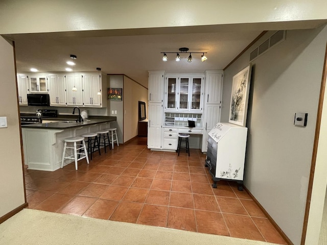 26136 E 2200 N Rd, Lexington, IL 61753 - kitchen with black microwave, stainless steel range with electric cooktop, heating unit, white cabinetry, and a kitchen breakfast bar