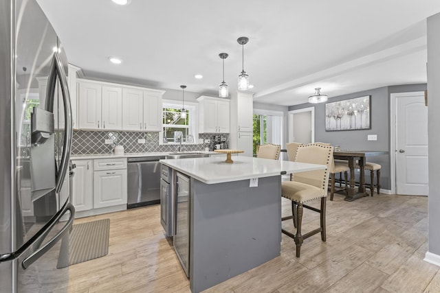 221 N 6th St, Saint Charles, IL 60174 - kitchen featuring stainless steel appliances, decorative backsplash, a kitchen breakfast bar, white cabinets, and light countertops