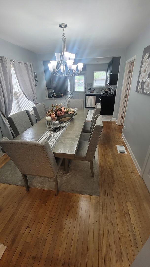 2676 N Julian Ter, River Grove, IL 60171 - dining room featuring a chandelier, hardwood / wood-style flooring, and baseboards