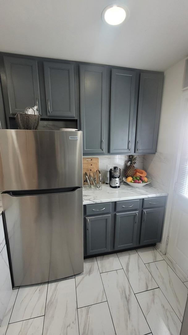 2676 N Julian Ter, River Grove, IL 60171 - kitchen with freestanding refrigerator, gray cabinets, light marble finish flooring, and light countertops