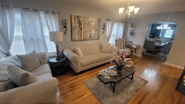 2676 N Julian Ter, River Grove, IL 60171 - living room featuring a chandelier, arched walkways, light wood-style flooring, and baseboards
