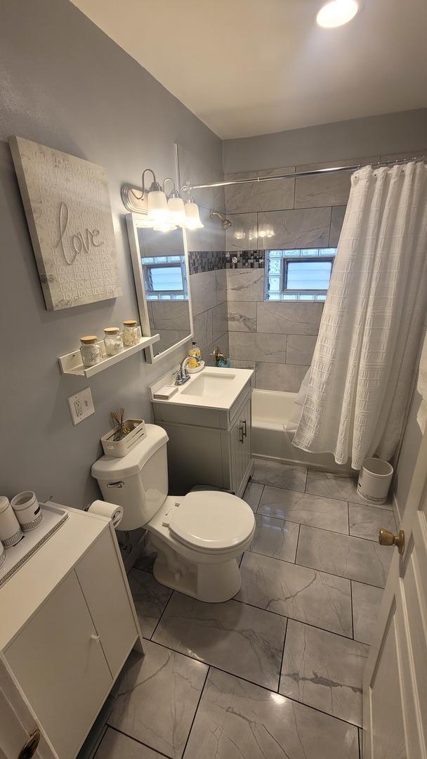 2676 N Julian Ter, River Grove, IL 60171 - bathroom with toilet, marble look tile flooring, shower / bathtub combination with curtain, and vanity