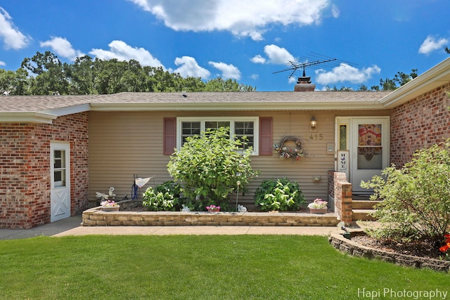 1415 Arabian Spur, Mchenry, IL 60051 - view of front of home with a front lawn, brick siding, a chimney, and roof with shingles