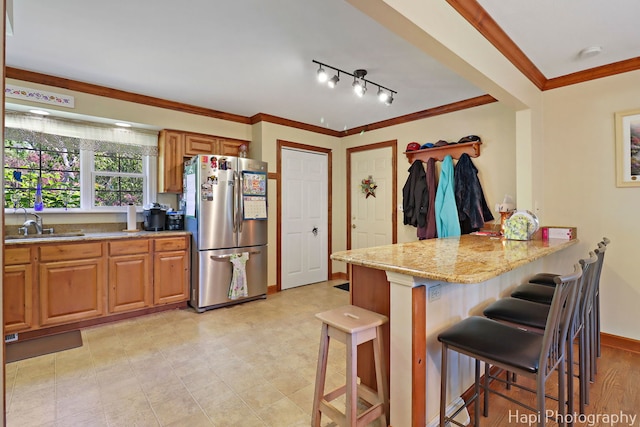 1415 Arabian Spur, Mchenry, IL 60051 - kitchen featuring freestanding refrigerator, light stone counters, ornamental molding, a breakfast bar, and a peninsula