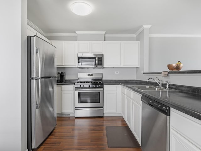 2455 Hillsboro Ln, Montgomery, IL 60538 - kitchen with appliances with stainless steel finishes, ornamental molding, dark countertops, white cabinets, and dark wood-style floors