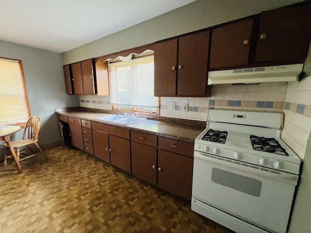 506 Scribner St, Joliet, IL 60432 - kitchen with white range with gas stovetop, under cabinet range hood, a sink, backsplash, and dark countertops