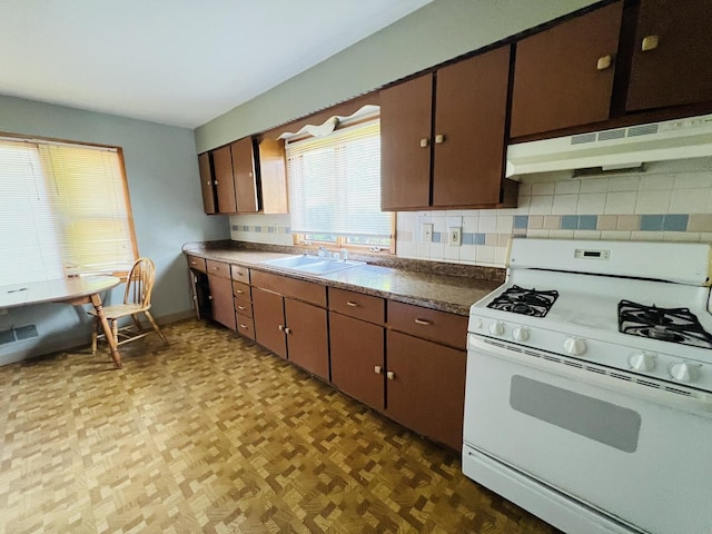 506 Scribner St, Joliet, IL 60432 - kitchen featuring white range with gas stovetop, under cabinet range hood, a sink, and backsplash