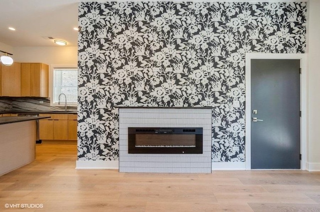 456 E Oakwood Blvd Unit 3, Chicago, IL 60653 - unfurnished living room with wallpapered walls, a sink, light wood-style floors, a glass covered fireplace, and baseboards