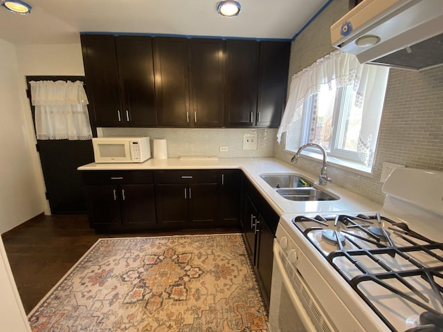2834 W Granville Ave Unit 2A, Chicago, IL 60659 - kitchen featuring white appliances, range hood, a sink, light countertops, and tasteful backsplash