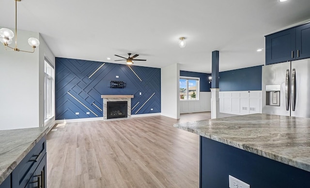 4951 W Ribbon Dr, Monee, IL 60449 - unfurnished living room with ceiling fan, light wood-style flooring, a fireplace, a chandelier, and a decorative wall