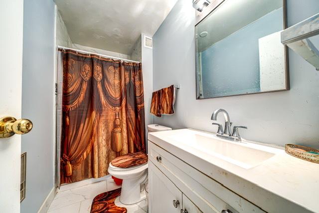 600 Naples Ct Unit 107, Glenview, IL 60025 - bathroom with marble look tiles, toilet, vanity, and a shower with curtain