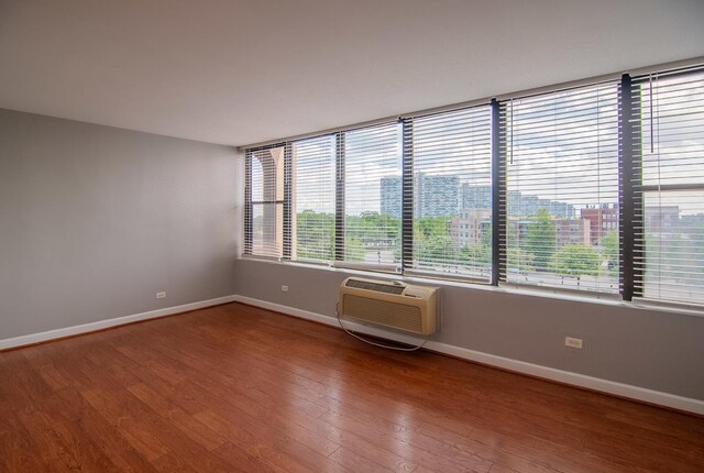 345 E Eastgate Pl Unit 505, Chicago, IL 60616 - empty room featuring a wall mounted AC, baseboards, and wood finished floors