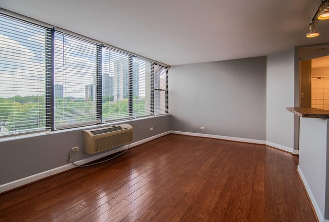 345 E Eastgate Pl Unit 505, Chicago, IL 60616 - spare room with wood finished floors, baseboards, a wall mounted AC, and rail lighting